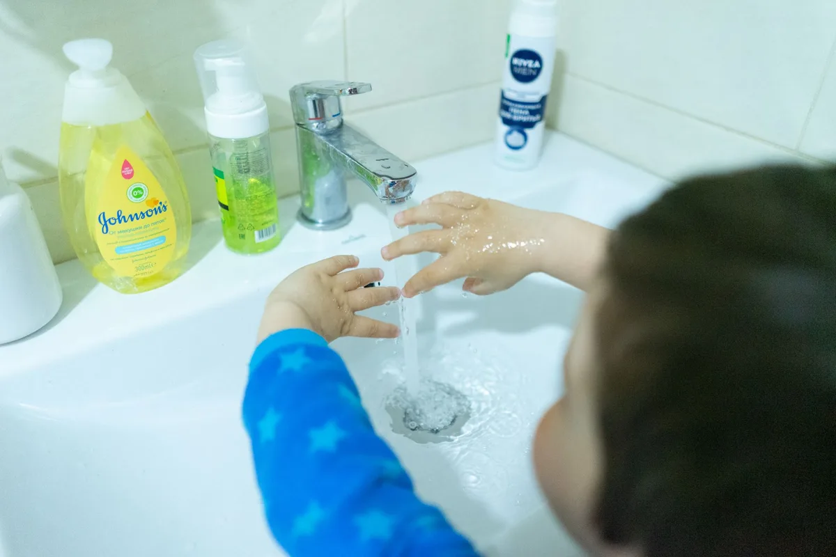 Kind of hand washing at sink with soap and water