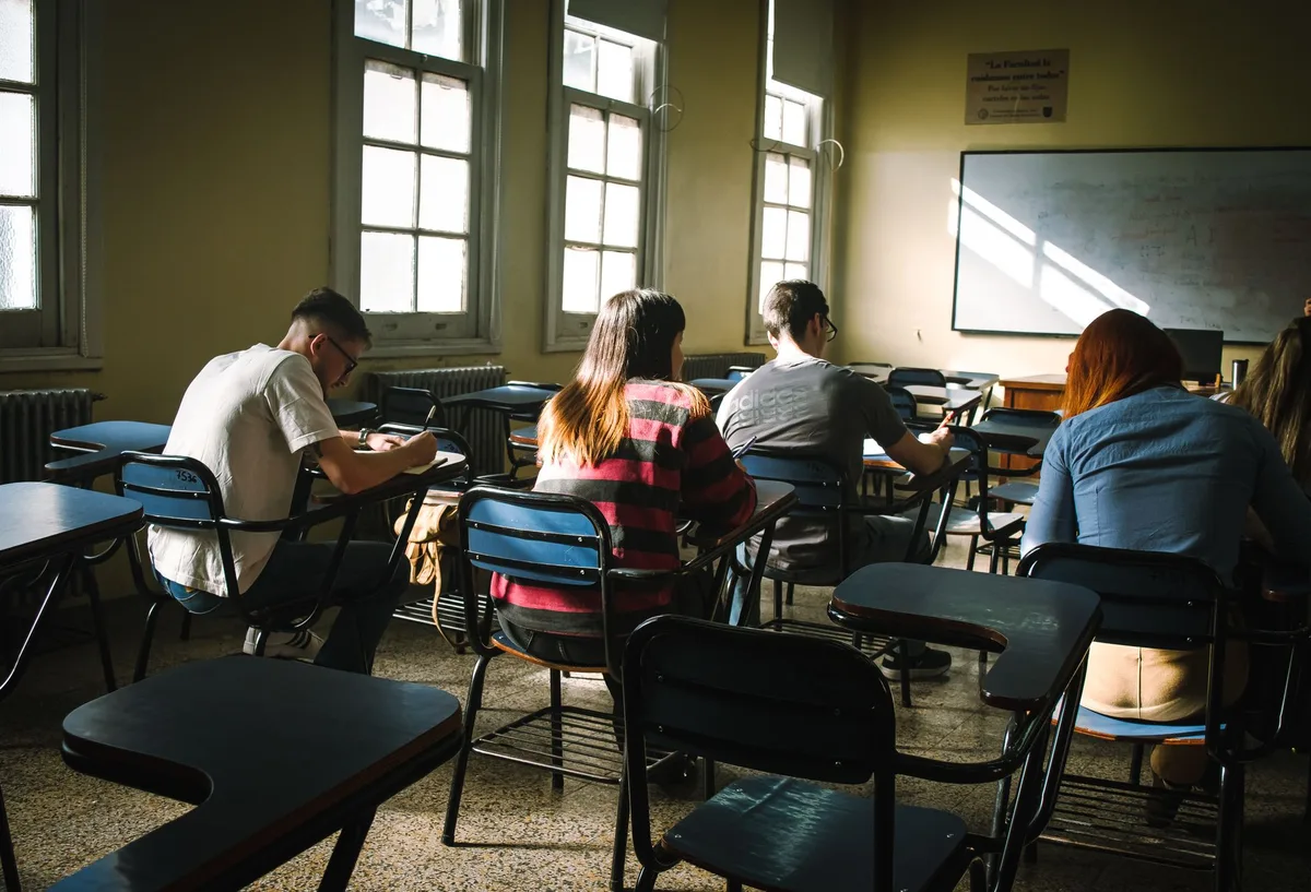 Children sitting close together at desks in a school classroom