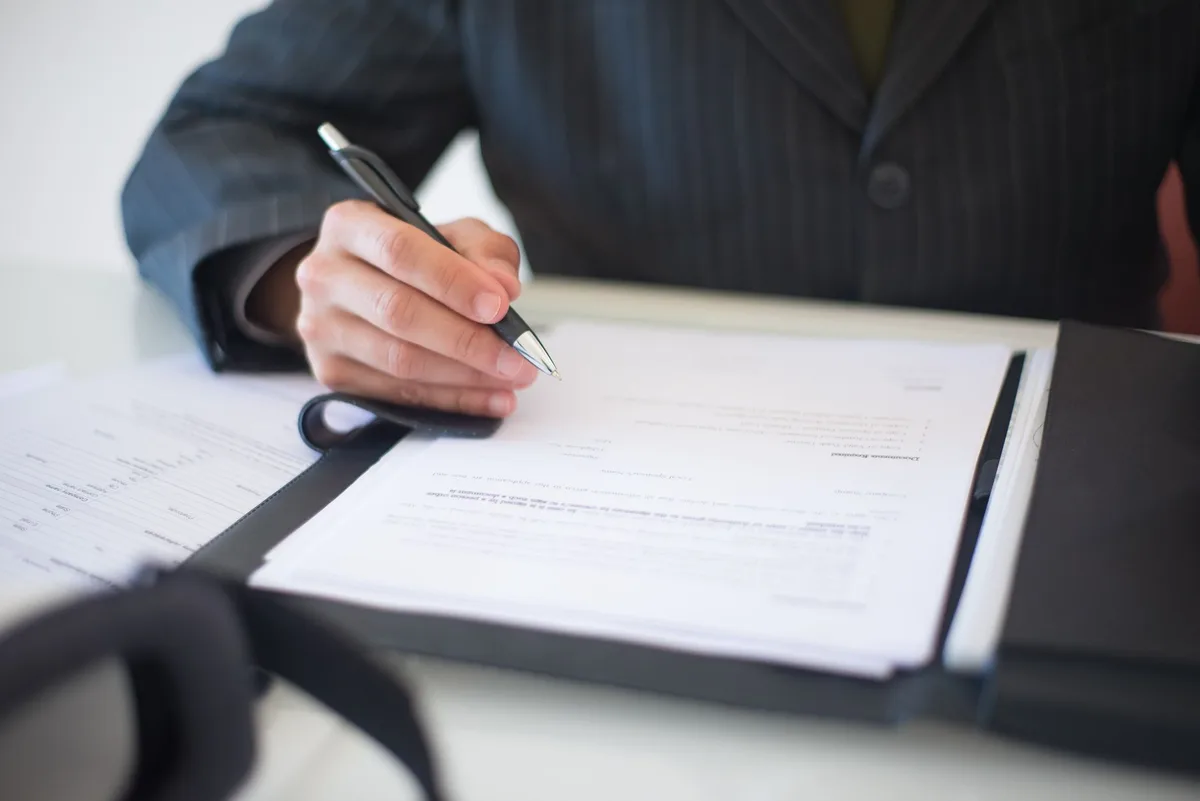 Small business owner reviewing legal documents and correspondence at a desk