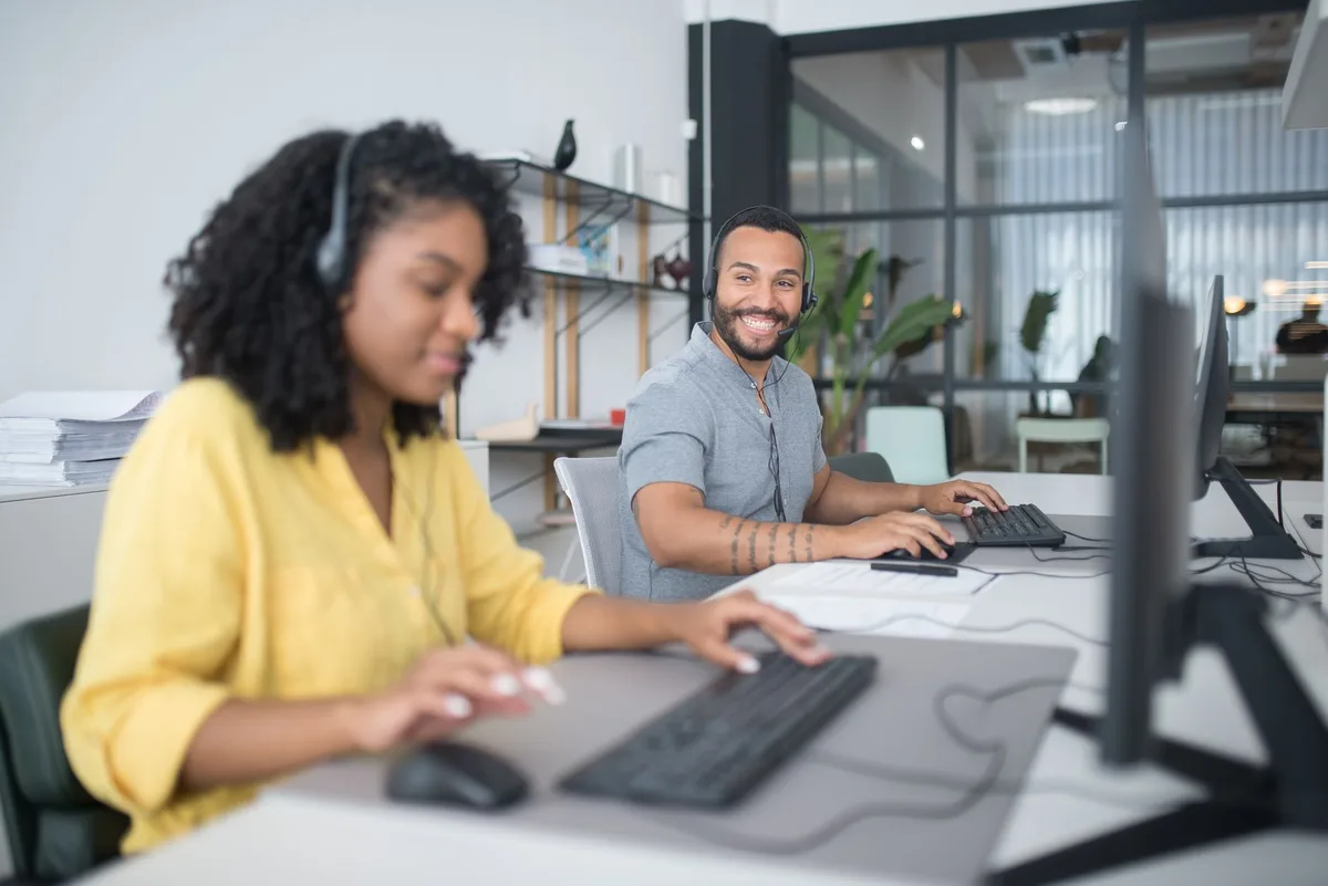 Customer service representatives working at desks in an office environment