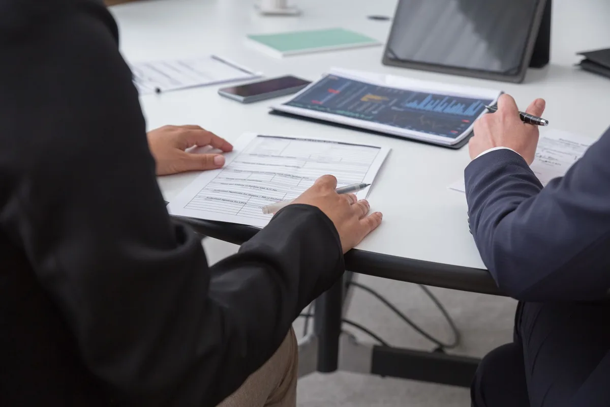 Federal and state regulators reviewing documents in a formal meeting environment