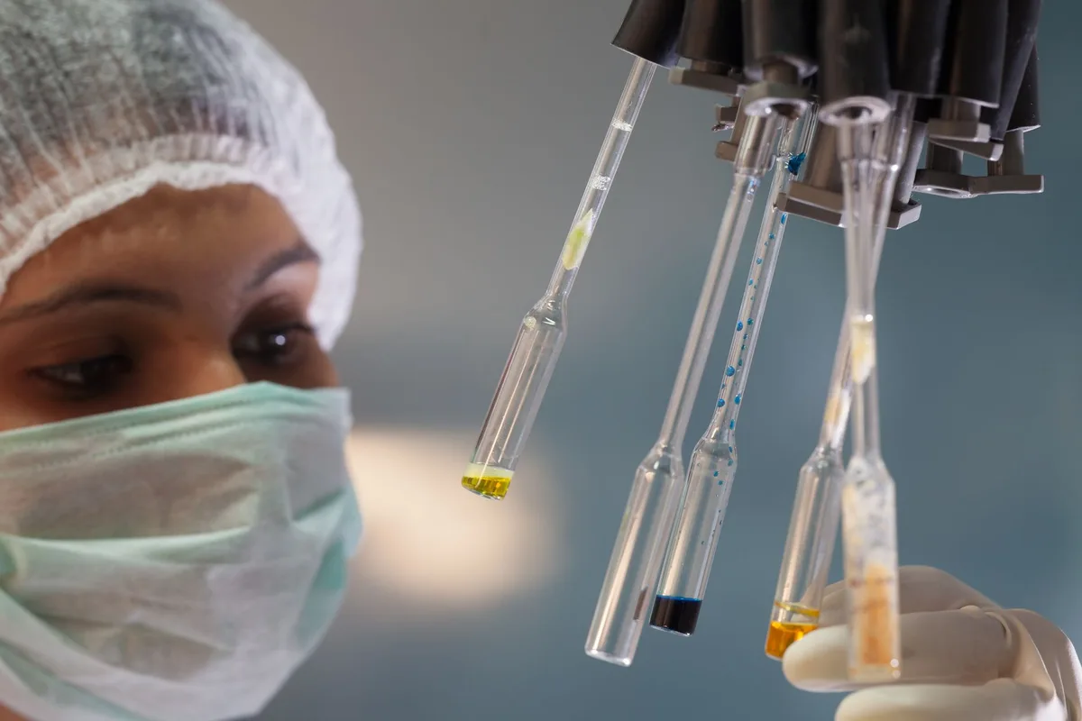 Laboratoriumwerker wat voedselmonsters ondersoek vir kontaminasie