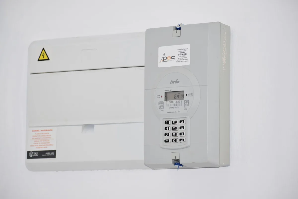 Technicians monitoring power grid systems on digital displays in a utility control room