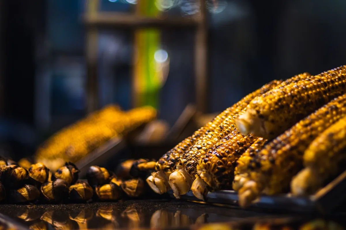 Charred corn kernels browning in a skillet over medium-high heat with onion and garlic