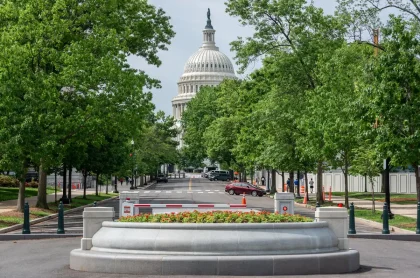 Capitol building with security barriers and law enforcement vehicles positioned outside