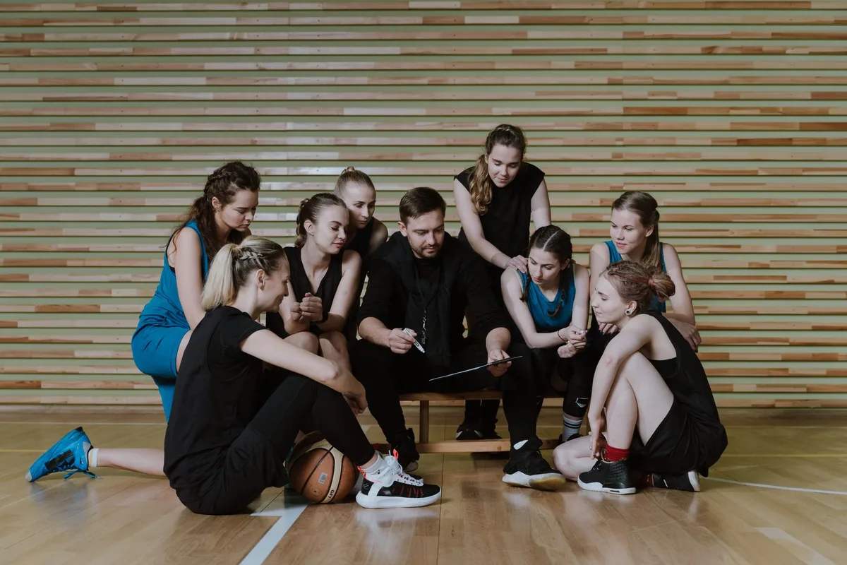 Trener koszykówki pracujący z zawodnikami na treningu w hali