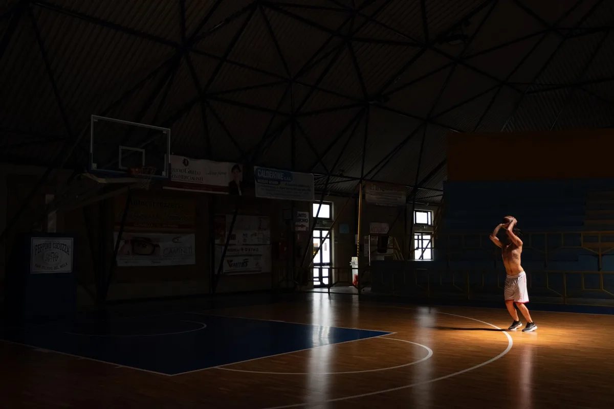 High school basketball players practicing on a court in a modern gymnasium facility