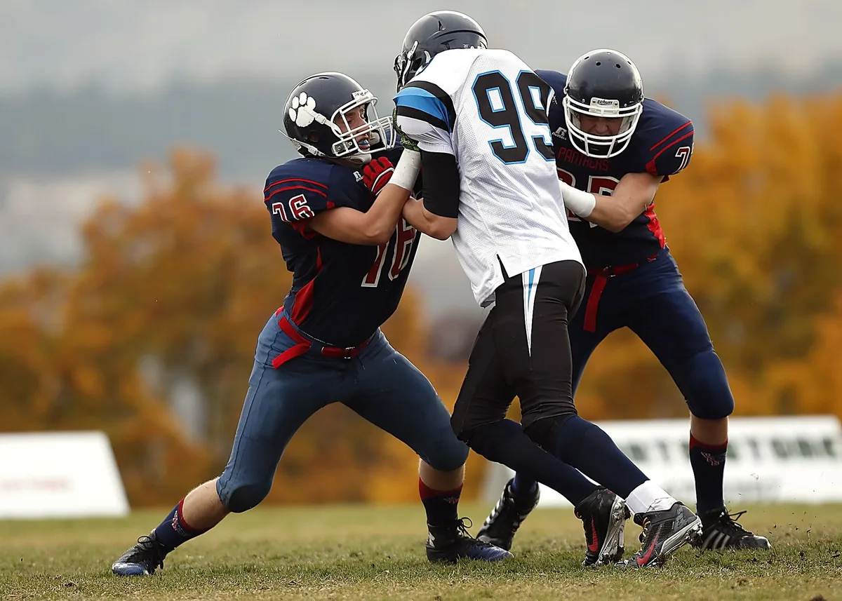 High school football defensive players executing formation during opening weekend game