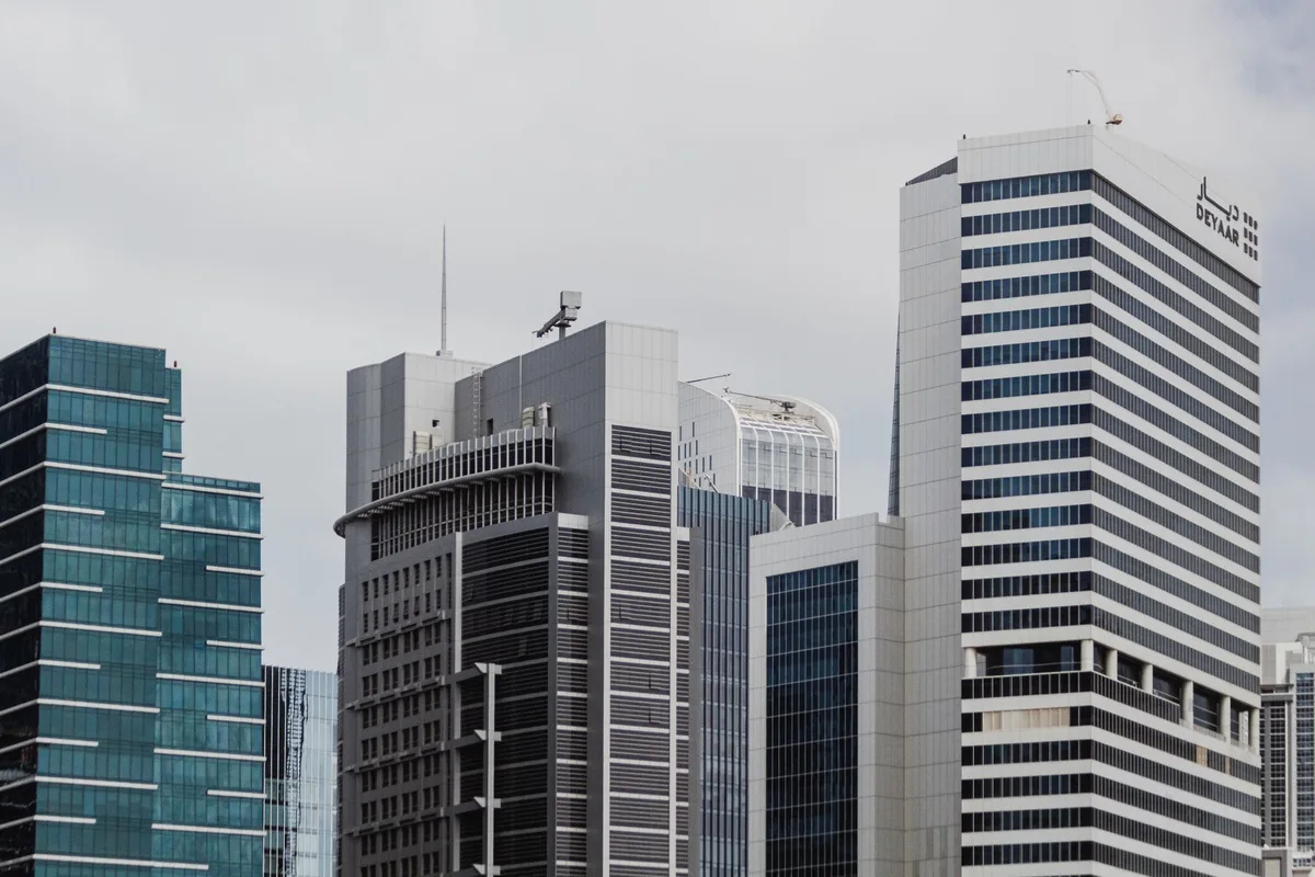 Tall modern skyscraper rising above a mixed-use urban development complex.