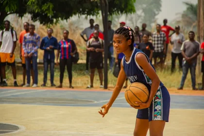 Female high school basketball player dribbling during a competitive game in a packed arena