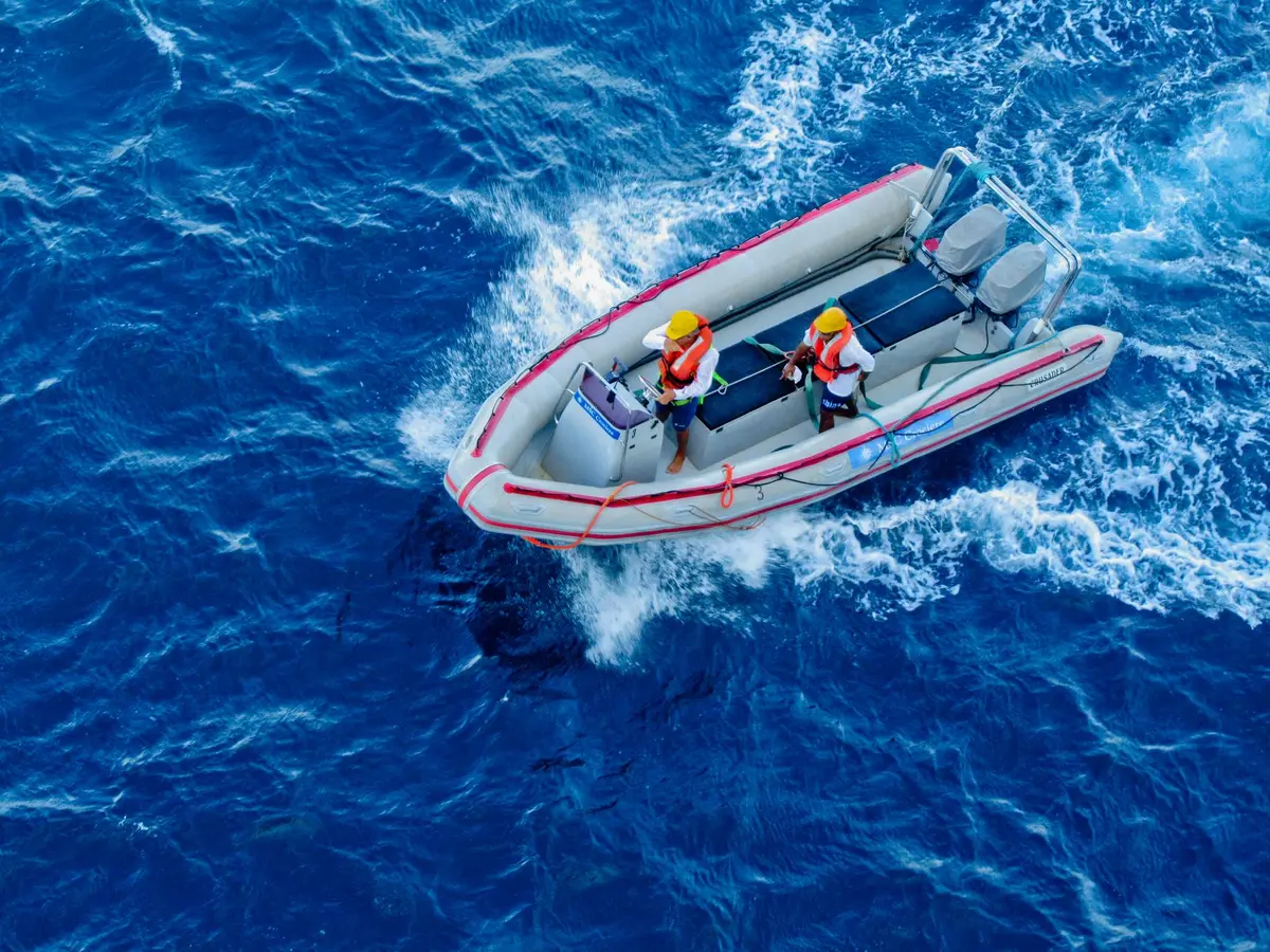 Emergency rescue teams conducting search operations on open water with multiple boats and personnel