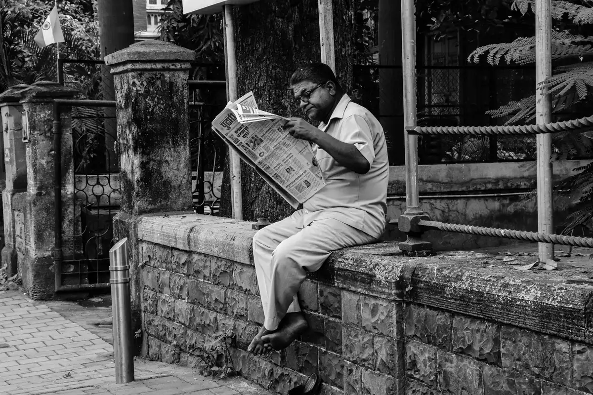 A resident reads local news on a tablet, engaged with community reporting.
