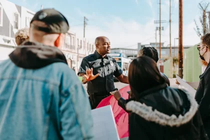 Neighbors gather at a community table to discuss local projects and share information.