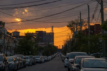 Brightly lit urban corridor with clean storefronts and pedestrians walking toward evening light