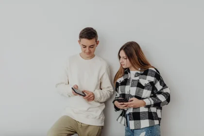 Young people looking at smartphones and mobile devices, scrolling through social media content.