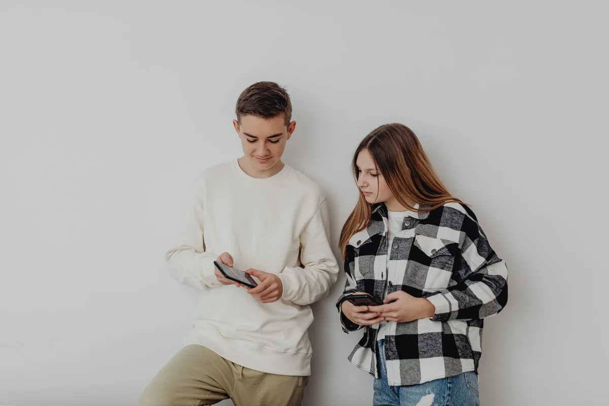 Young people looking at smartphones and mobile devices, scrolling through social media content.