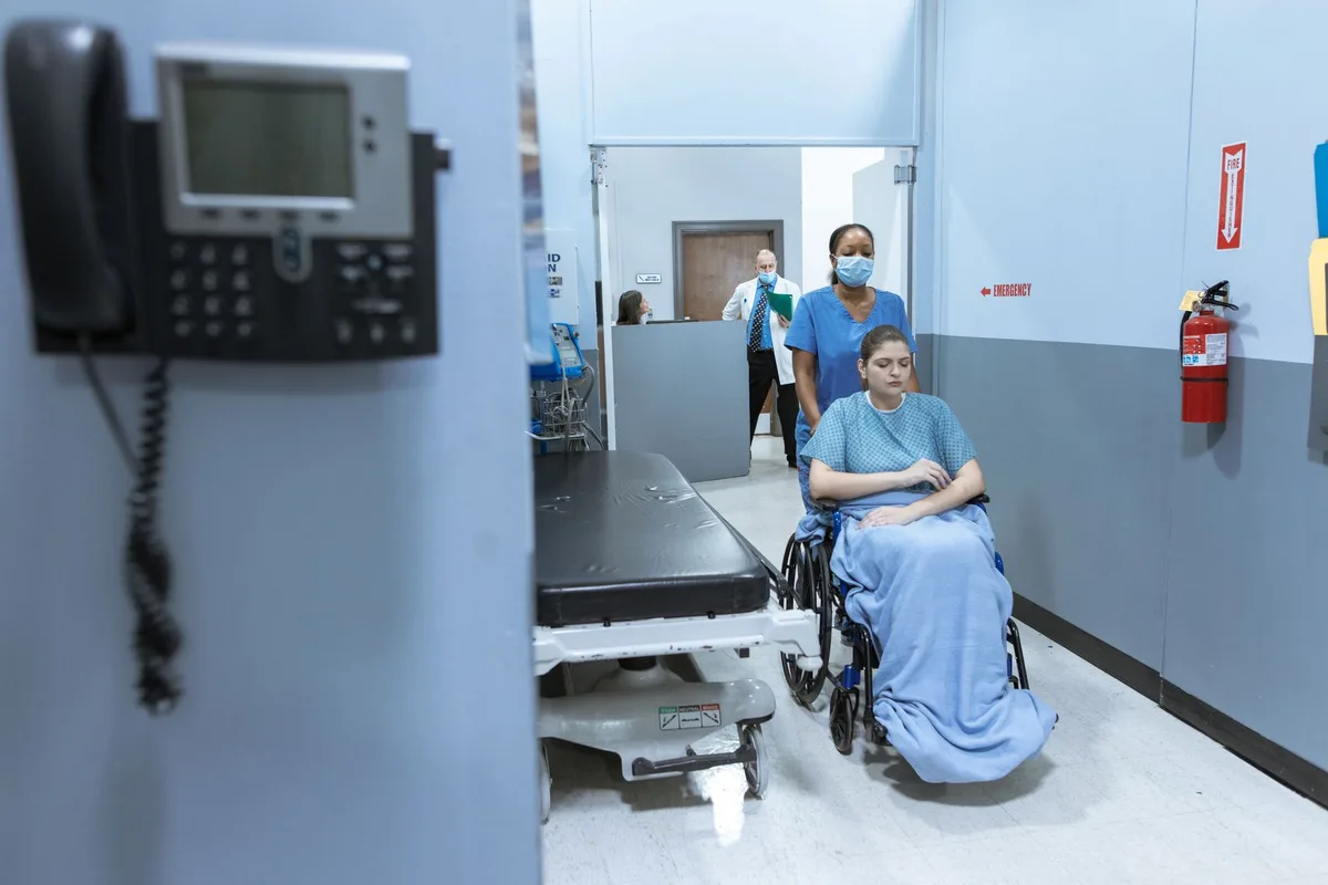 Healthcare worker assisting an older adult in a medical setting during heat-related illness treatment