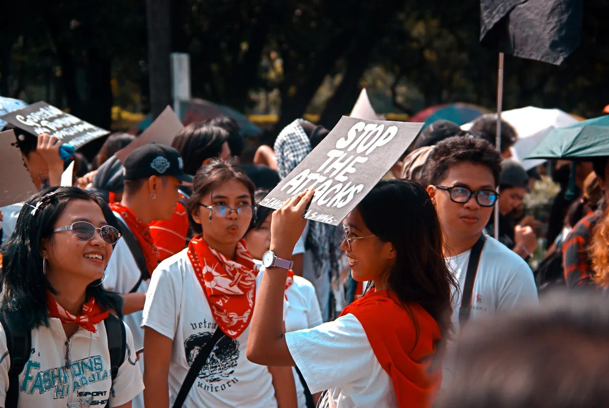 Crowd of students gathered at a campus rally, listening and engaged