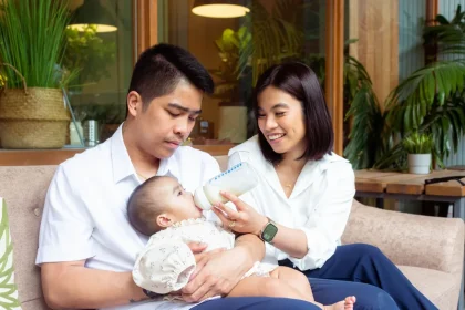 Parent holding an infant formula bottle during feeding time at home