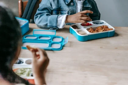 Students at school cafeteria tables with limited meal portions during lunch period