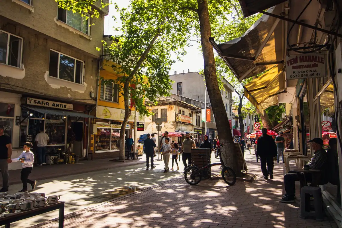 A vibrant neighborhood street with independent shops, galleries and pedestrians walking between storefronts