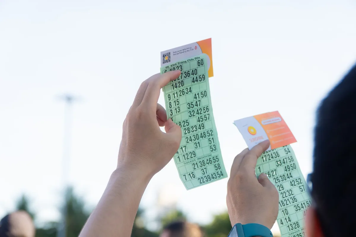Lottery ticket showing winning numbers held in hands
