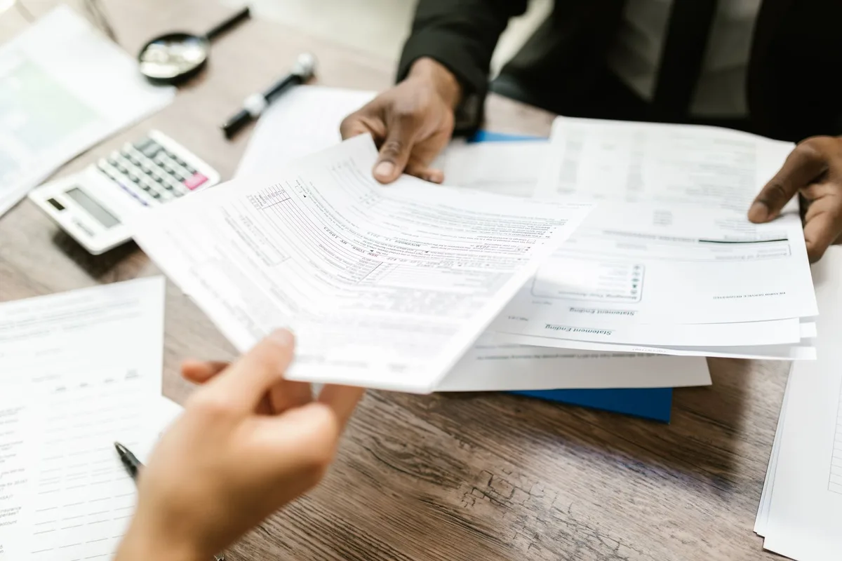 Rejected insurance claim papers and roof damage documentation on a work surface