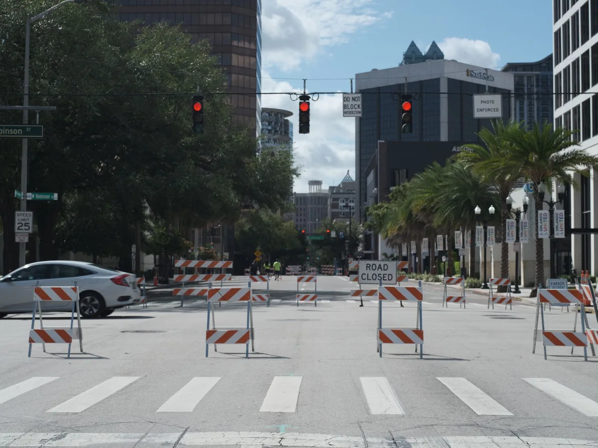 Closed street section marked with barriers creating a dedicated skating lane through an urban neighborhood.