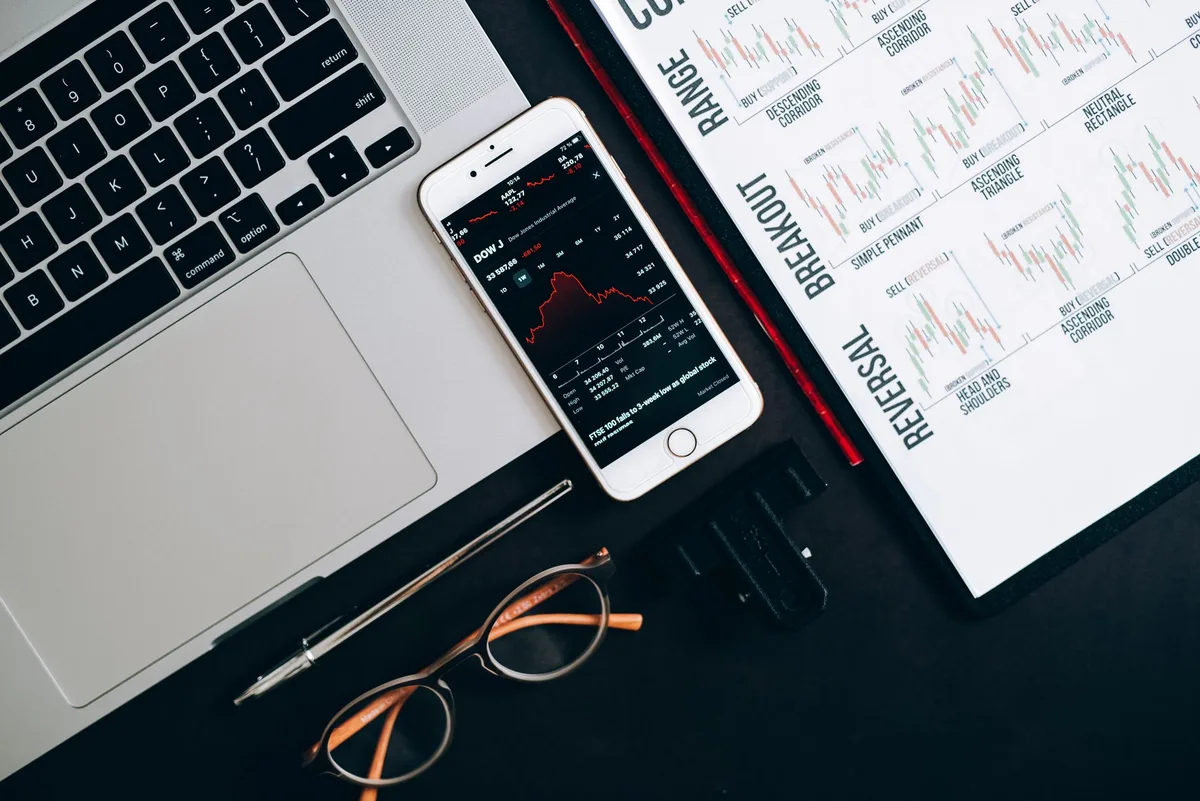 Financial charts and market data displayed on desk with calculator and papers
