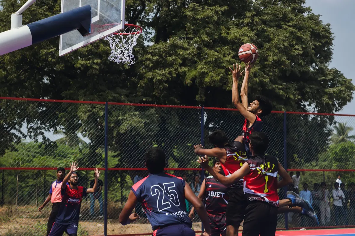 Player jumping for a rebound near the basket during intense competition