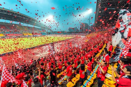 Female basketball players celebrating with raised arms and confetti after winning a championship game