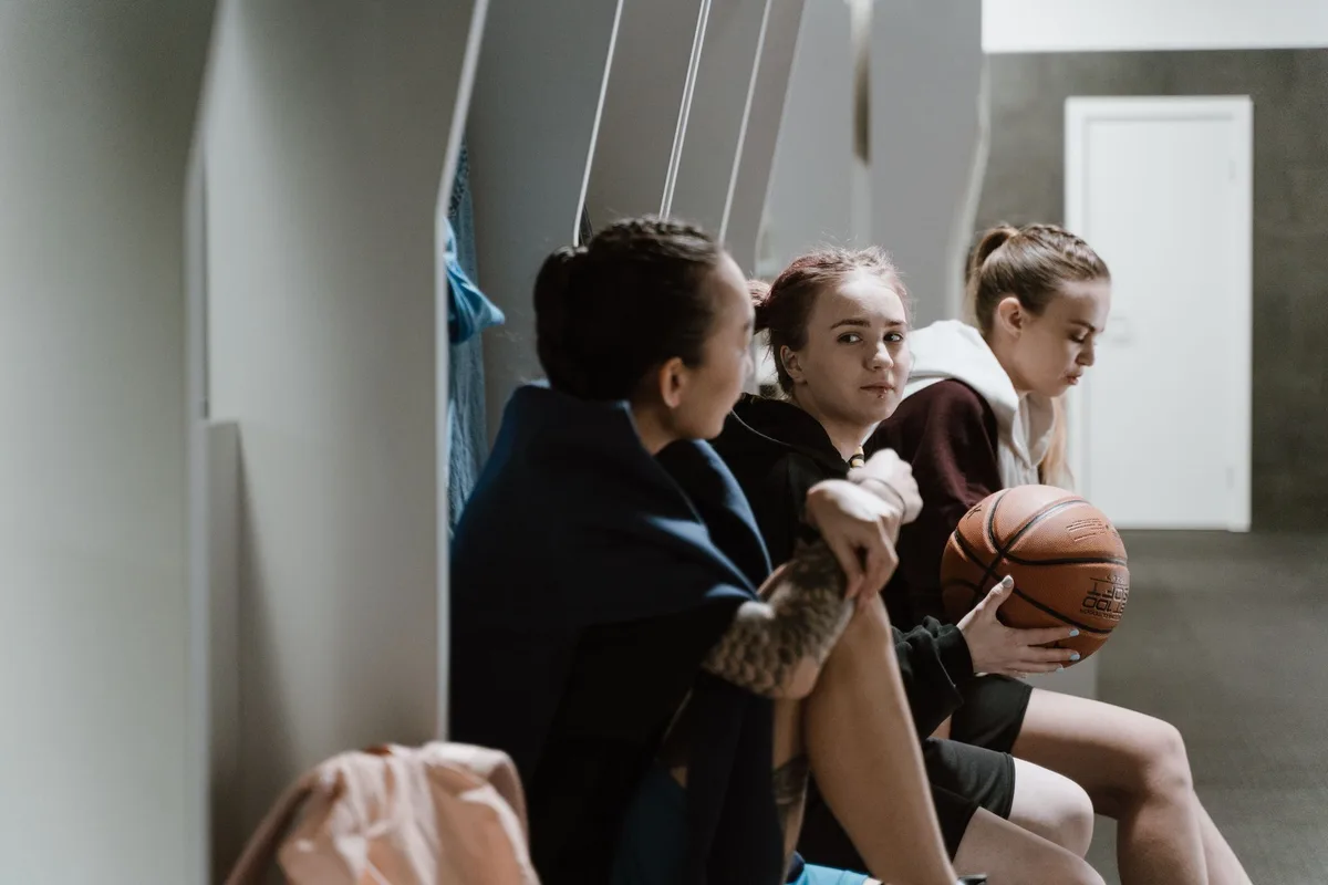 Young female basketball player shooting from three-point range during high school practice