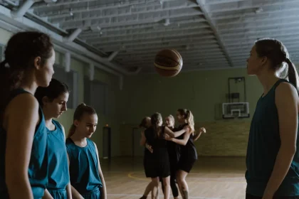 Basketball soaring through a net in an arena during a three-point shooting contest