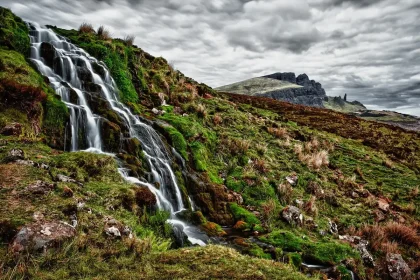 Waterfall cascading into a natural swimming hole surrounded by rocky Arbuckle Mountains landscape and forest