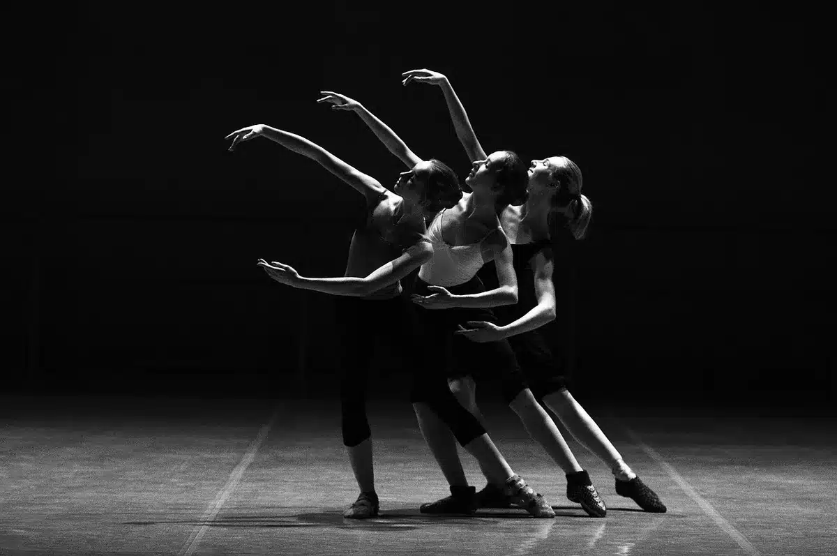 Diversos artistas en el escenario: bailarín, músico e intérprete de teatro durante una actuación en vivo.