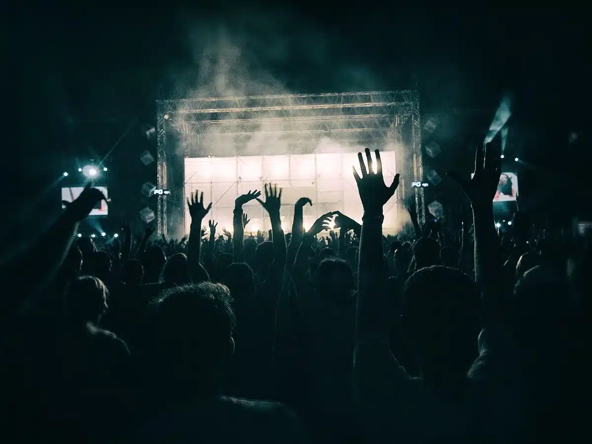 Crowd of people line dancing together at an outdoor country music venue