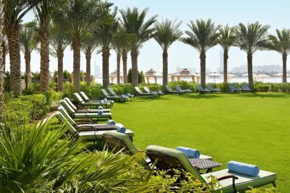 Modern hotel suite with floor-to-ceiling windows overlooking a stadium and rooftop pool area
