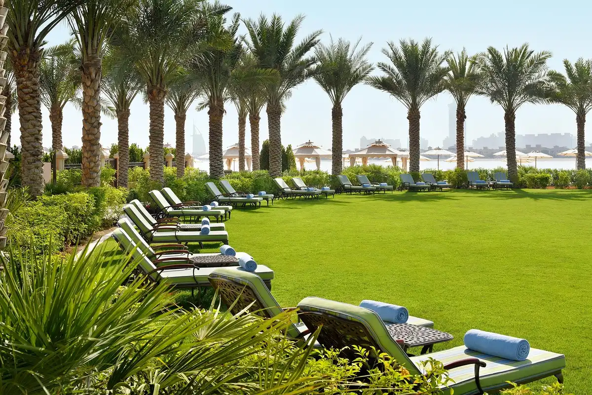 Modern hotel suite with floor-to-ceiling windows overlooking a stadium and rooftop pool area