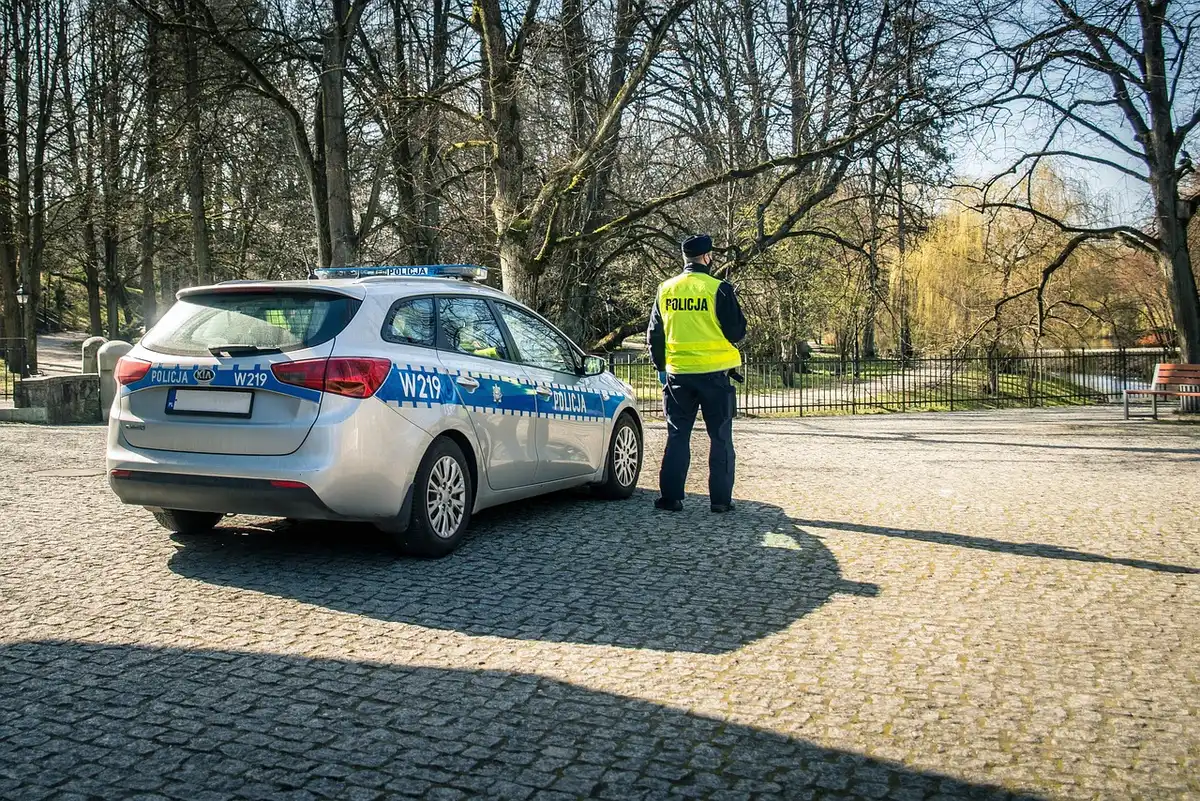 Police officer with grant paperwork beside a patrol vehicle