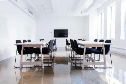 Hands and documents on a sunlit conference table with city skyline through large windows