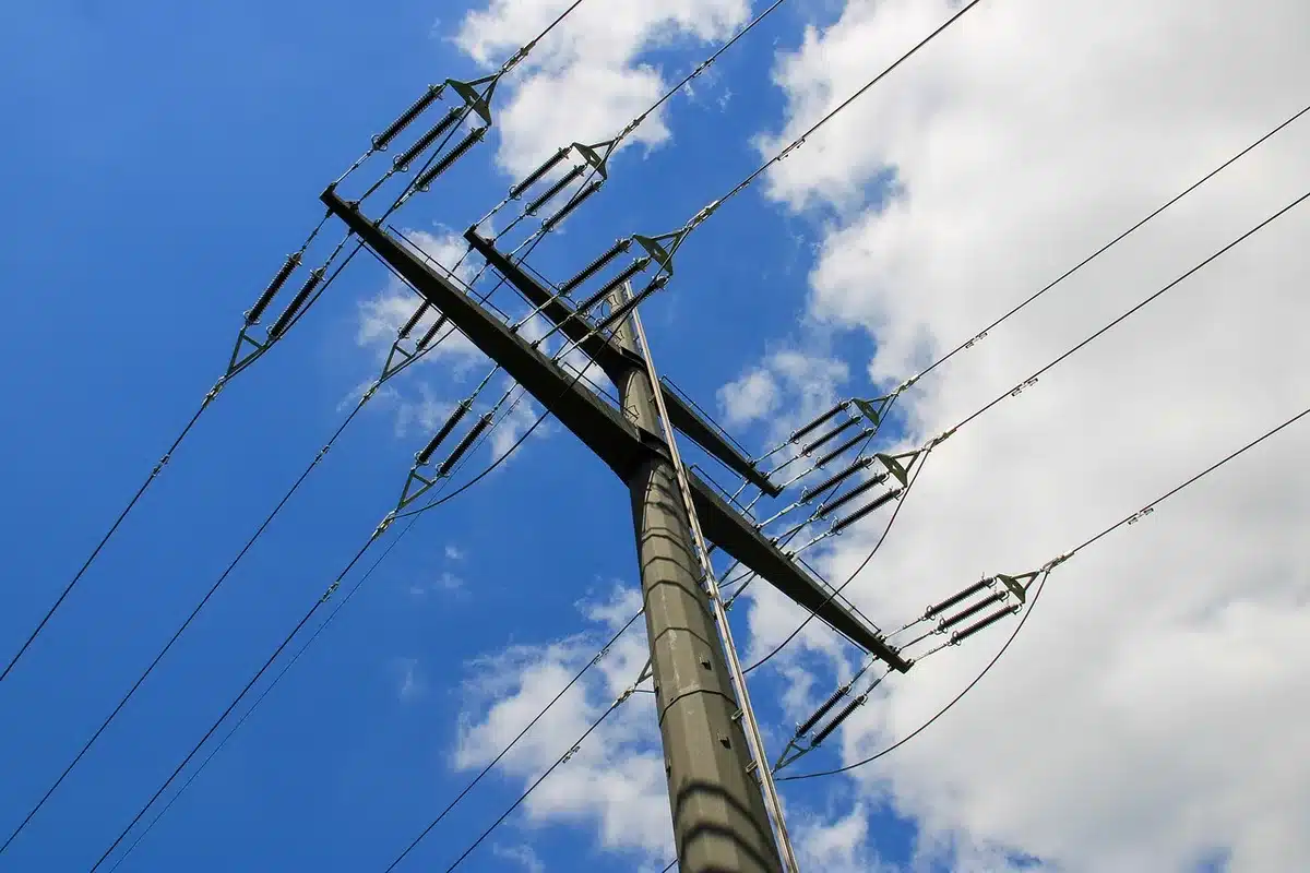Engineering plans on a desk with transmission lines visible outside a window