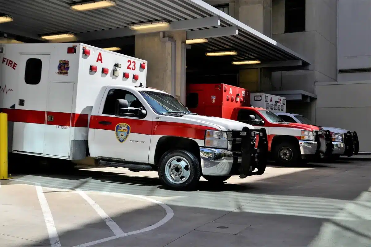 Emergency responders and vehicles at a traffic crash scene on a local road