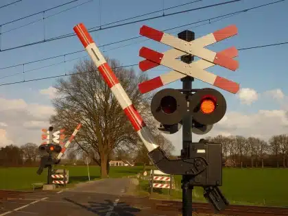 Emergency responders at a highway-rail crossing with flashing lights and accident scene