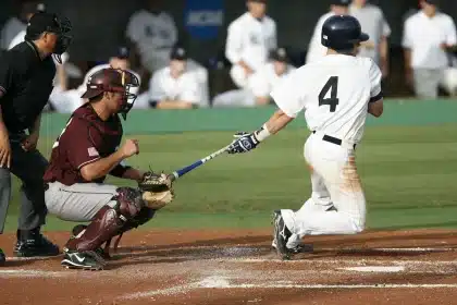 High school baseball players competing at a state tournament with spectators in the background