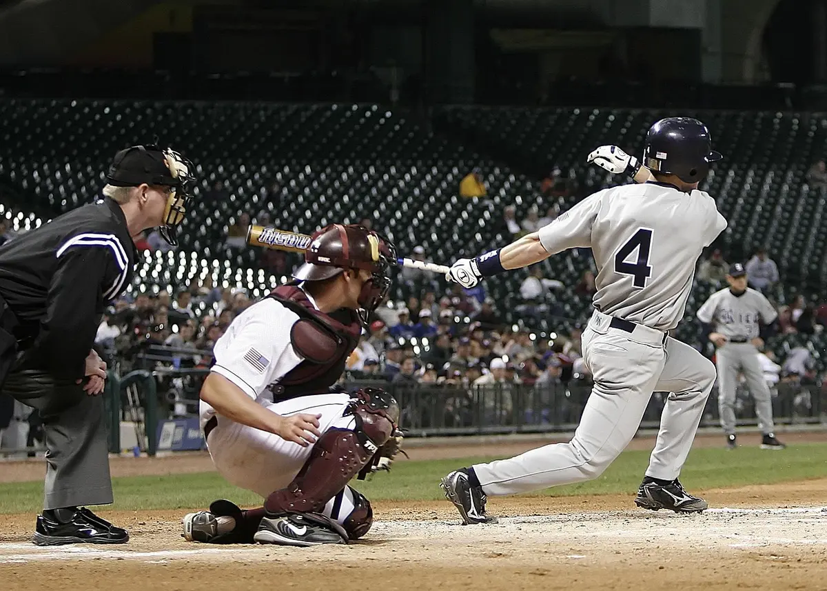 A high school baseball player mid-swing during a game