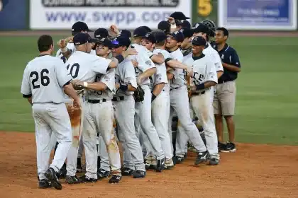 High school baseball players competing on field during championship game with spectators in bleachers