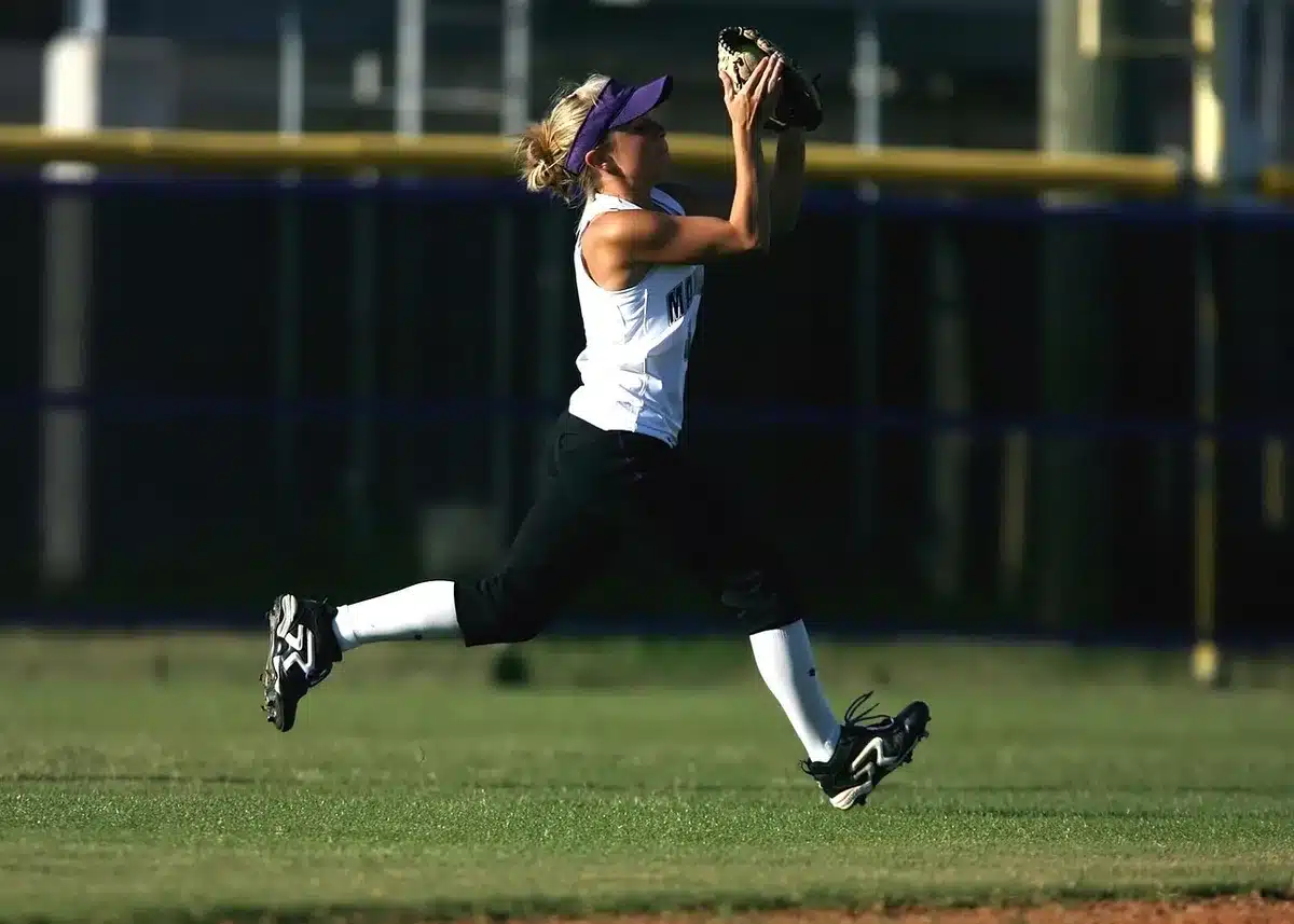 A batter swinging at a pitch during a high school softball game