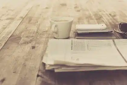 Hands over policy papers on a sunlit conference table near large windows