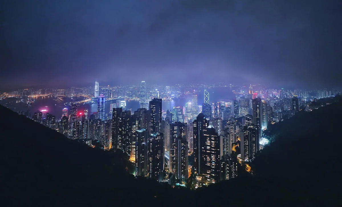 Cityscape shrouded in hazy smog with reduced visibility and amber-toned air quality warning conditions