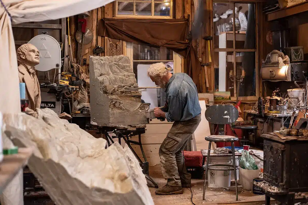 Artist or fabricator working on a public art sculpture in a studio or workshop